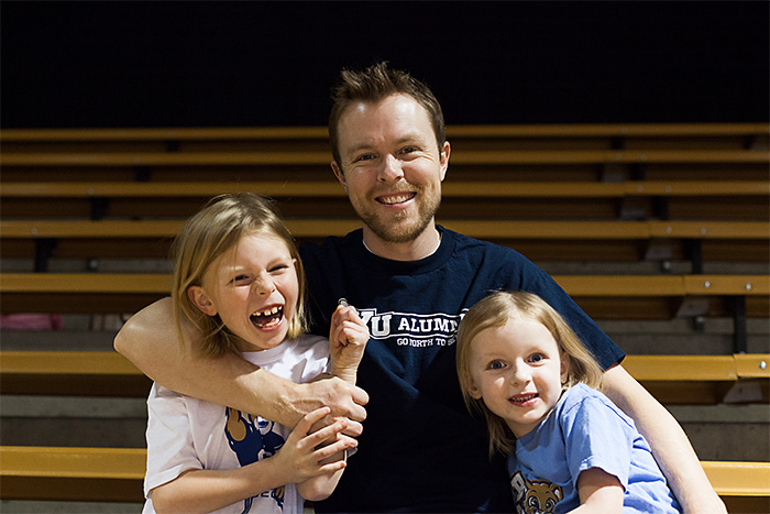 Bart Francis with his two daughters, Addison and Hannah in the bleachers of a BYU Basketball game
