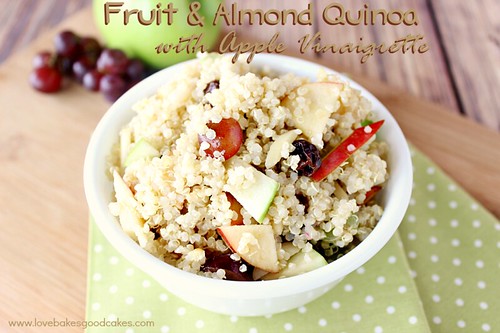 Fruit and Almond Quinoa with Apple Vinaigrette in white bowl with fresh fruit. 