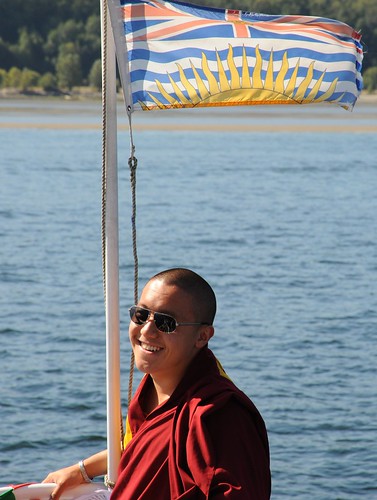 Dilgo Khyentse Yangsi Rinpoche, on board a ship, wearing sunglasses, being photographed (by many photographers out of the frame),  semchen tsetar tangpa, British Columbia, Canada by Wonderlane