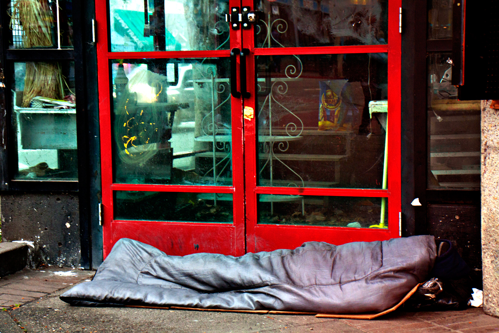 Sleeping-person-outside-red-framed-doors-in-3-13--Berkeley
