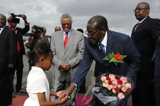 Republic of Zimbabwe President Robert Mugabe receives flowers from Ethiopian child when arriving for the African Union Summit in Addis Ababa, Ethiopia on January 28, 2014. by Pan-African News Wire File Photos