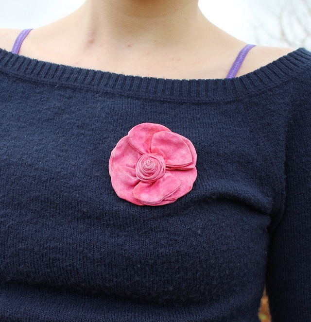 pink rose brooch on navy blue sweater