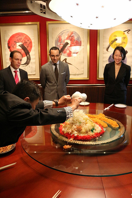 Manager Mr Ng pours the various sauces onto the yusheng