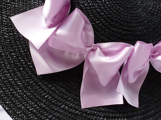 black straw hat trimmed with lavender silk satin ribbon bows
