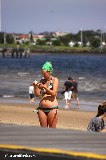 st kilda beach girl putting on tan