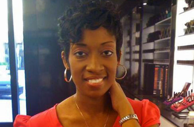 Marissa Alexander, a black woman with short hair wearing an orange shirt and hoop earrings.