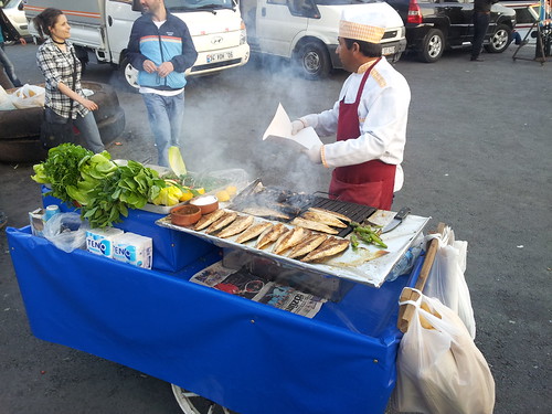 Man selling grilled fish sandwiches on the street