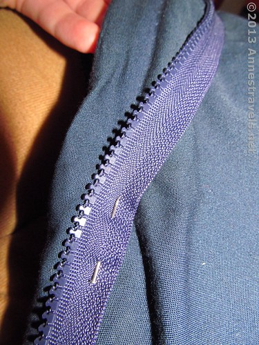 Pinning on the new zipper to a sleeping bag whose zipper has been removed