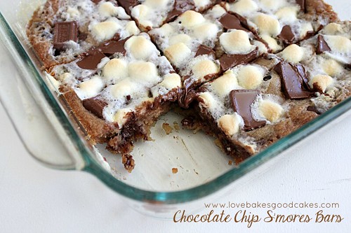 Chocolate Chip S'mores Bars in glass dish with piece removed.