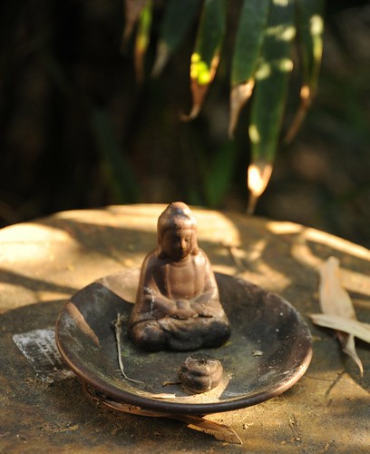 Small meditating Buddha, ceramic, plate, wood, bamboo leaves, garden, South Bay Vajrayana, Cupertino, Silicon Valley, California, USA by Wonderlane