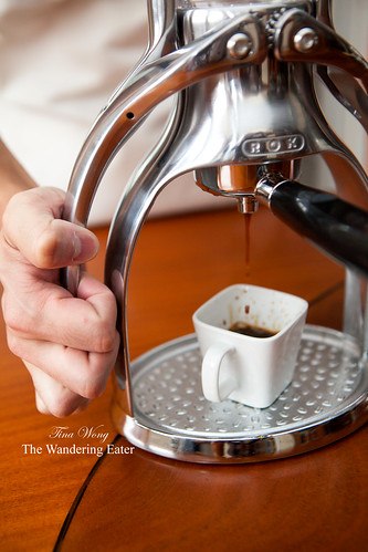 Stream of espresso dripping down while pressing