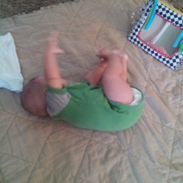 Someone has found his toes and is trying to roll from back to tummy. #growingtoofast