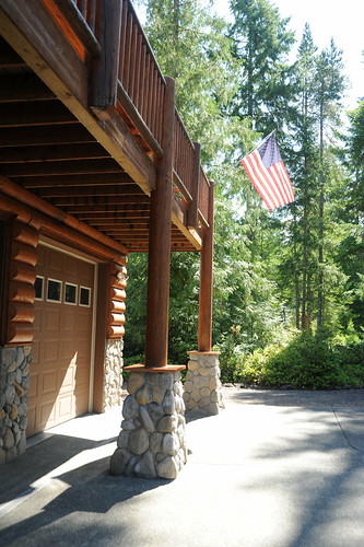 Entrance to the cabin, American Flag, logs, copper, river rock, trees, garage door, second floor deck, Alderbrook Golf Course, Union, Washington, Pacific Northwest, USA by Wonderlane