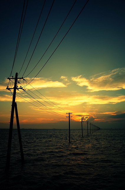 sunset scene with poles into the sea