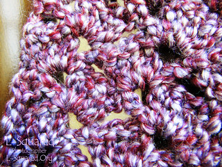 close-up of the thick, fuzzy purple yarn  which is actually made up of a dark maroon-purple strand, a medium violet-gray strand and a light purple-pink strand all twisted together.