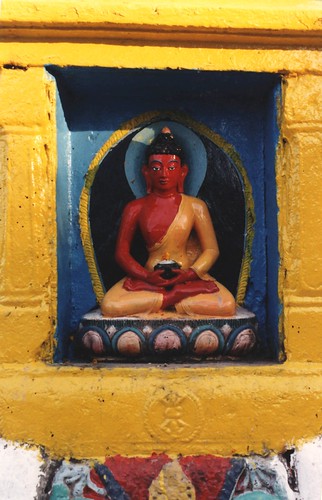 Statue of a red Buddha holding a begging bowl, blue and yellow aura, pink and blue lotus, stupa niche, vajra, Swayambhunath, Kathmandu, Nepal by Wonderlane