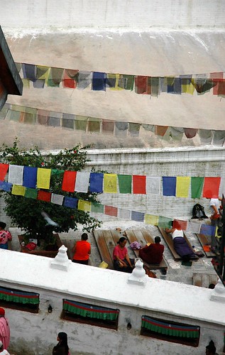Prostrators on prostration boards, Tibetan prayer flags, inside Boudha Stupa, Boudhanath, Kathmandu, Nepal by Wonderlane