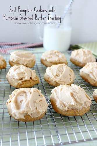 Soft Pumpkin Cookies with Pumpkin Browned Butter Frosting on cooling rack and a glass of milk.