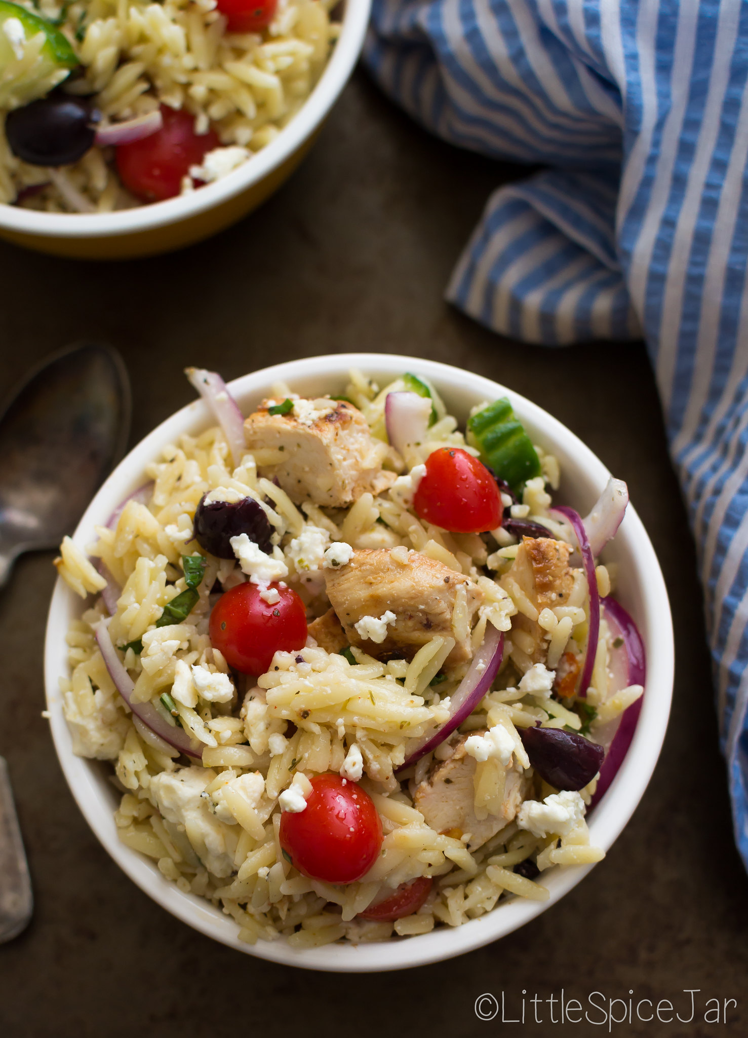 orzo pasta salad with chicken in bowls on sheet pan