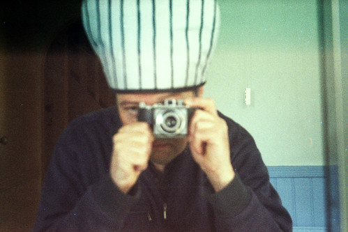 reflected self-portrait with Agfa Karat camera and stripy hat by pho-Tony