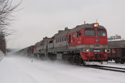 Diesel locomotive 2М62У-0063 kicks up snow while hauling mixed freight