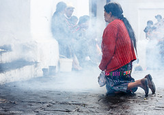 Entering San Tomas church by crawling in on bended knee. Mayan shamans burn candles and incense and perform their rituals on the steps to the church.  - Chichicastenango