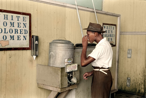 "Negro drinking at 'Colored' water cooler in streetcar terminal, Oklahoma City, Oklahoma" ca. July 1939