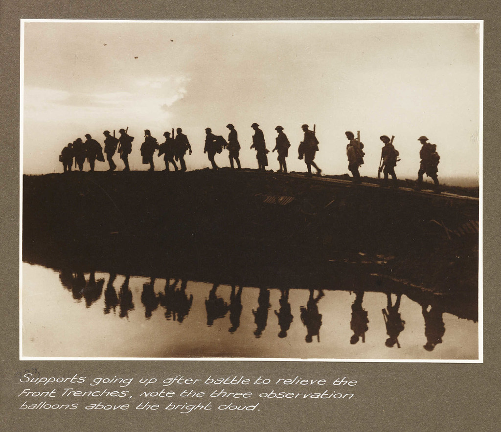 Supports going up after battle to relieve the front trenches, note the three observation balloons above the bright cloud
