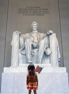 A little girl seeks inspiration in front of the statue of Abraham Lincoln