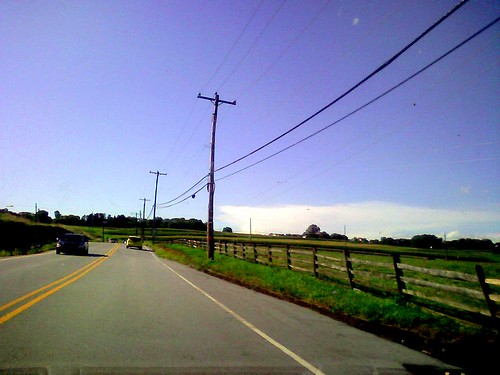 cameraphone road trees sky cars clouds fence wires takenwhiledriving myobsession postcardsfromnowhere pa113 frameismorethantwothirdsempty