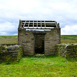 A small stone shed with no roof.