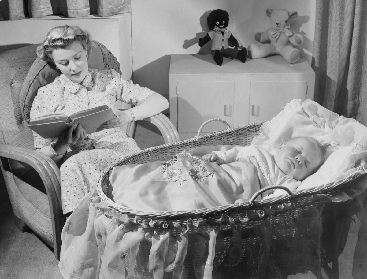 Woman reads as baby sleeps