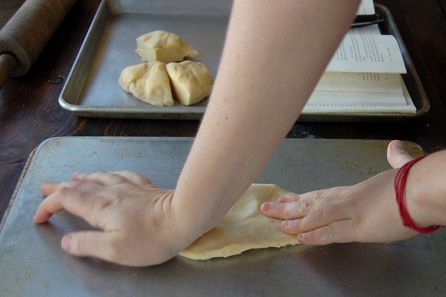 Flattening the dough enough to feed it into the pasta roller