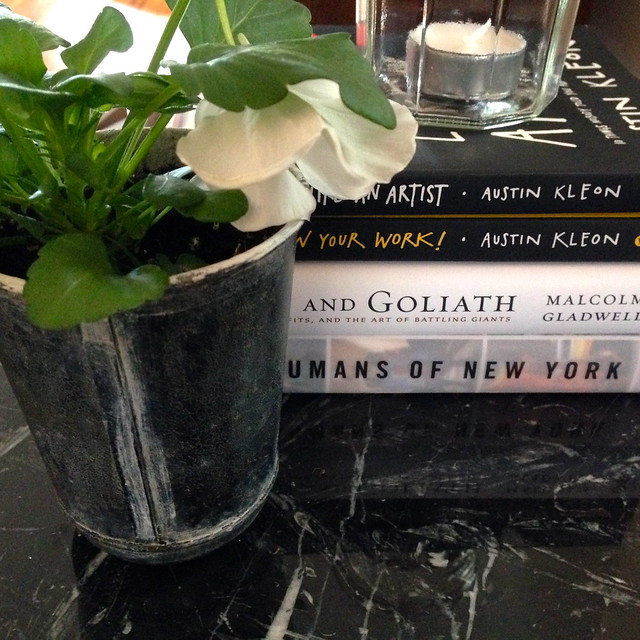 Pansies and books on black marble Saarinen table