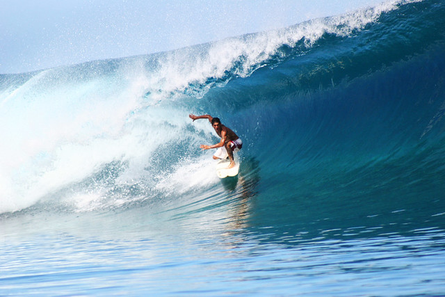 A surfer riding the perfect wave at Teahupoo, Tahiti.