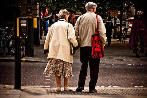 Elderly couple waiting to cross urban street