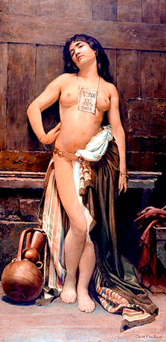 nude slave woman posing agains wall, Latin placard around her neck