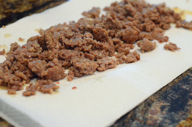Cooked crumbled sausage draining on paper towels.