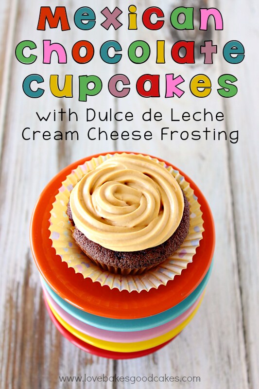 Mexican Chocolate Cupcake with Dulce de Leche Cream Cheese Frosting on a stack of colorful bowls.