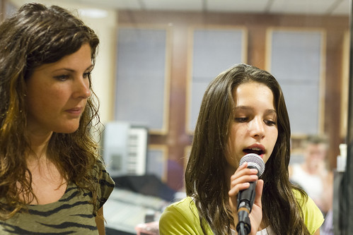 Een zangcoach kijkt mee met een leerling