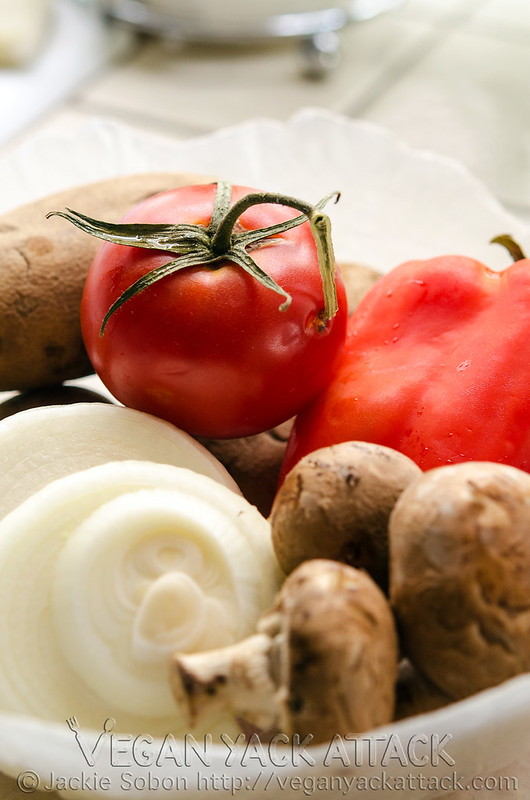 Close up shot of onions, tomatoes, mushrooms, and bell peppers in a bowl