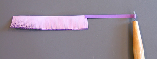 fringed quilling strips on a slotted tool ready to be rolled into a flower