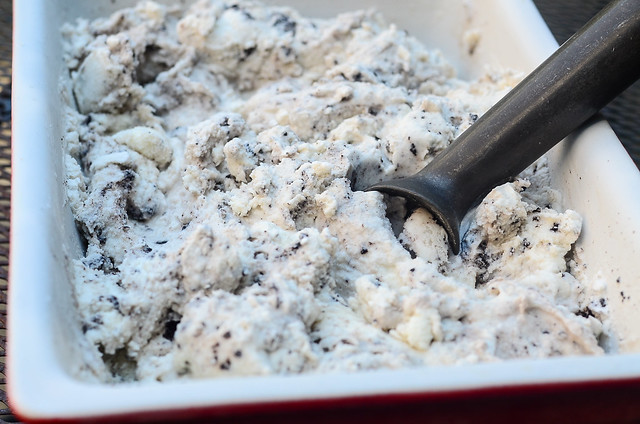 An ice cream scoop, scooping out some Easy Homemade Cookies and Cream Ice Cream.