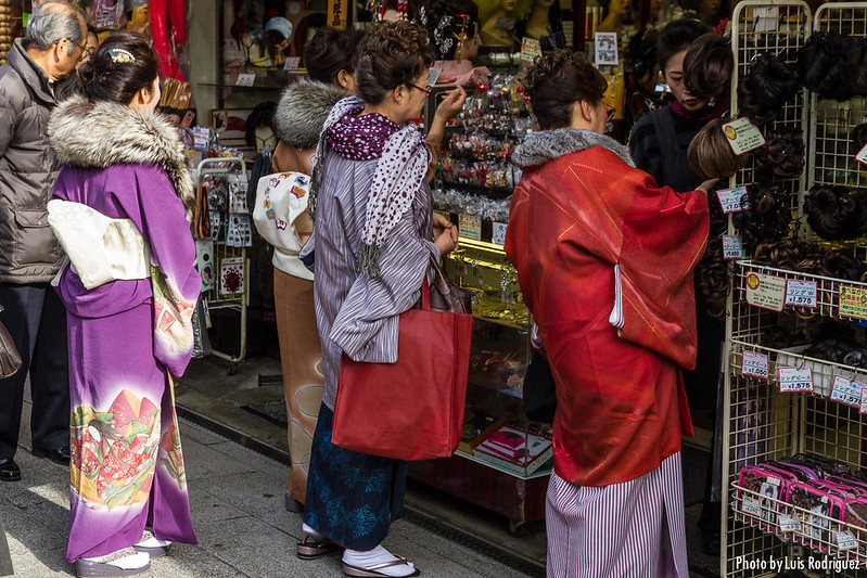 Mujeres en kimono mirando las tiendas de la calle Nakamise