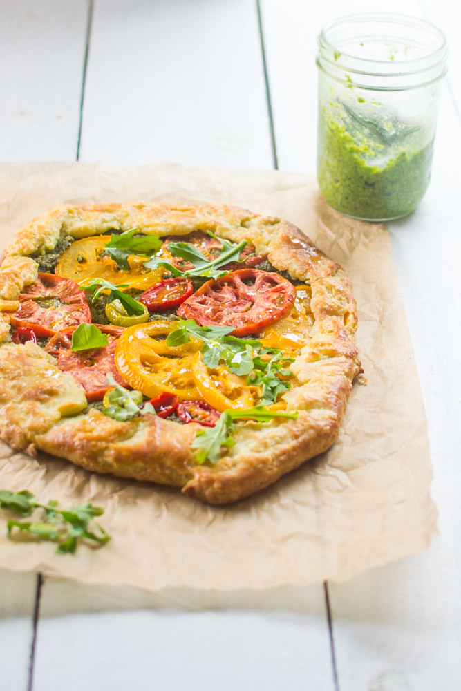 This rustic heirloom tomato galette features summers sweet heirloom tomatoes that are layered on top of spicy arugula pesto.