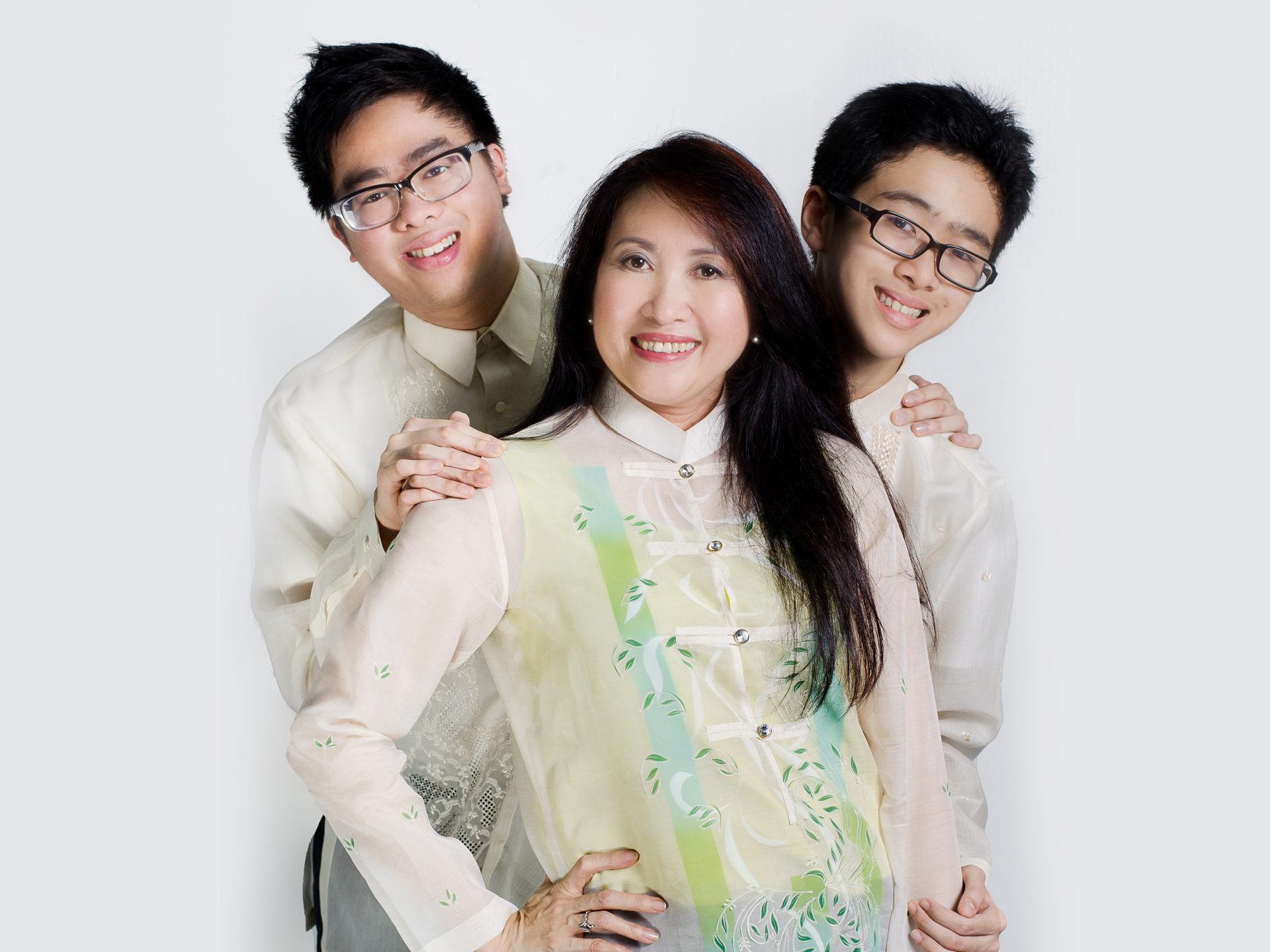 The image shows a mom Ms. Peng So with two sons named Patrick and Angelo wearing Barong Tagalog. Ms. Peng has long hair and her boys wearing eyeglasses.