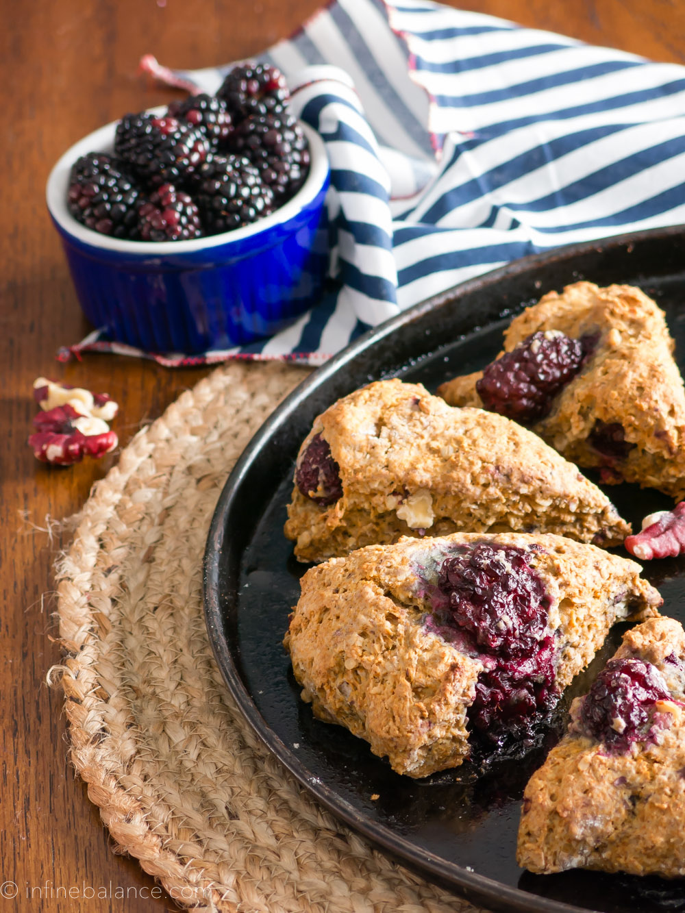blackberry and walnut scones on a baking tray, blackberries in the background