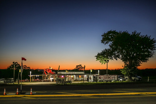 texas waller wallercounty crawfishshak gaintcrawfish restaurant flags cowboy fiigure street road tree cones parkinglot sunset twilight lights signs
