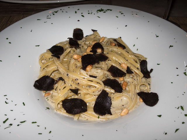 Pasta in a cream sauce, topped with shaved black truffles and parmesan cheese