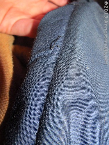 The old stitching line on the sleeping bag from which a broken zipper has been removed